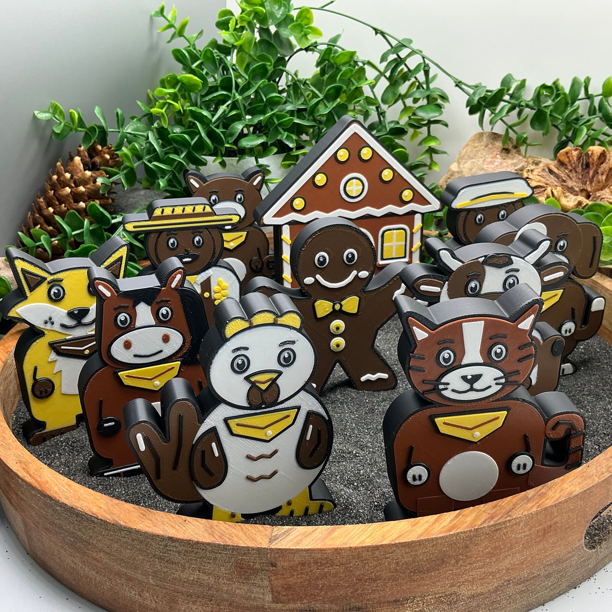 Close-up of the colourful animal figures with the gingerbread house and characters behind