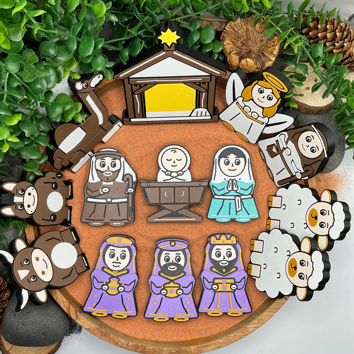 Complete 14-piece Nativity set laid flat in a wooden tray, with stable, Mary, Joseph, baby Jesus, three wise men, angel, shepherd, two sheep, donkey, ox and camel