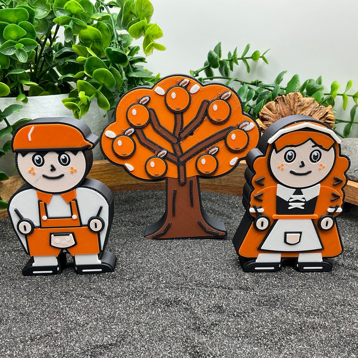 Large Hansel and Gretel characters with an orange tree in a wooden sand tray