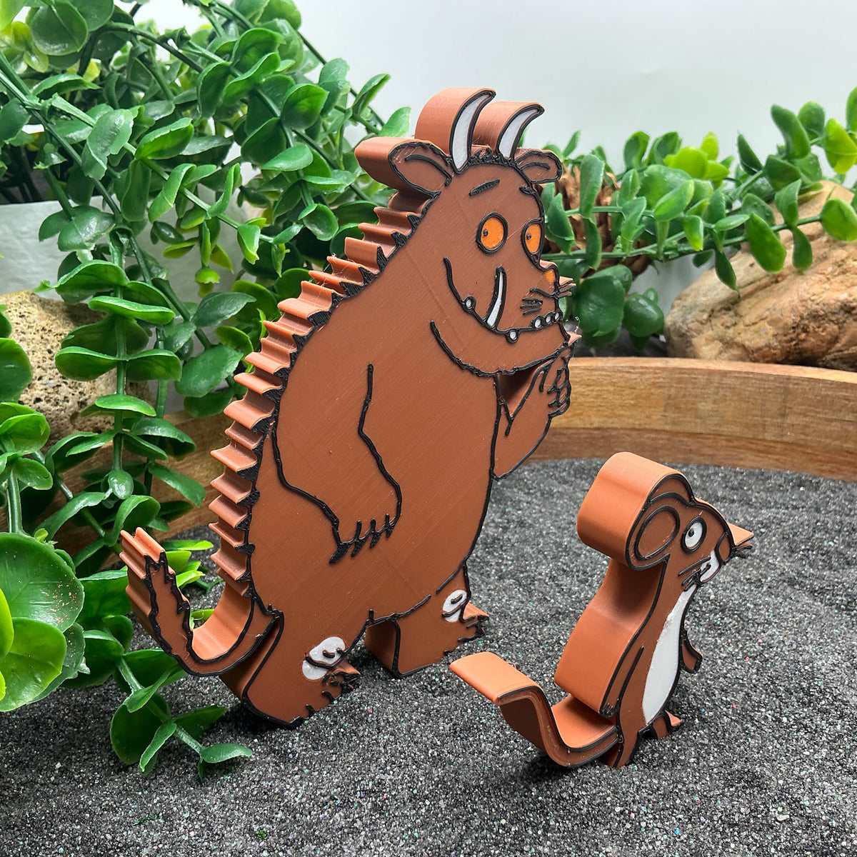 Forest monster and mouse figures standing in sand