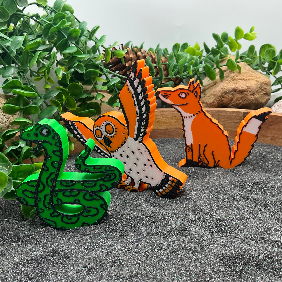 Close-up of snake, owl and fox figures
