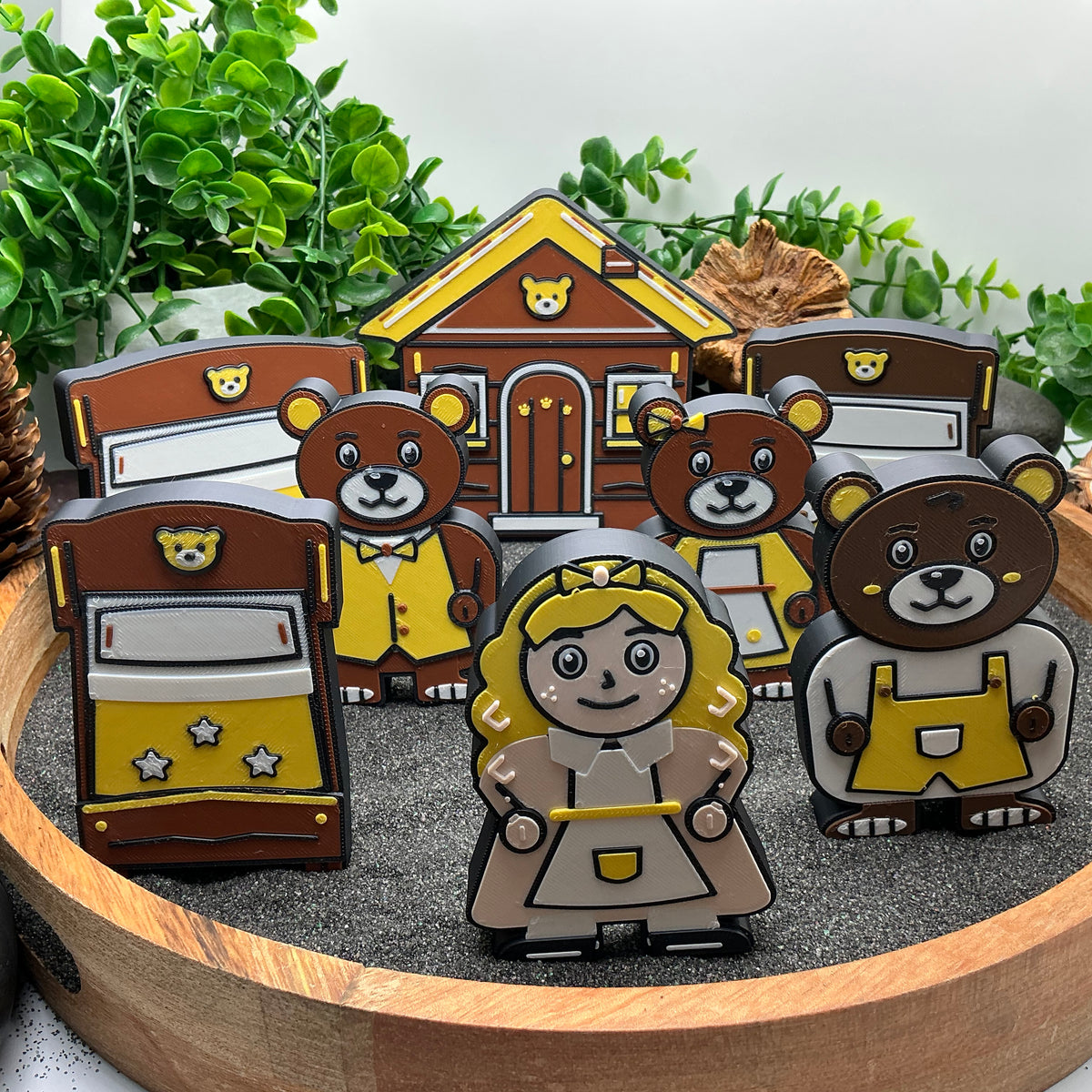 Large Goldilocks, three bears, three beds and cottage standing together in a sand tray