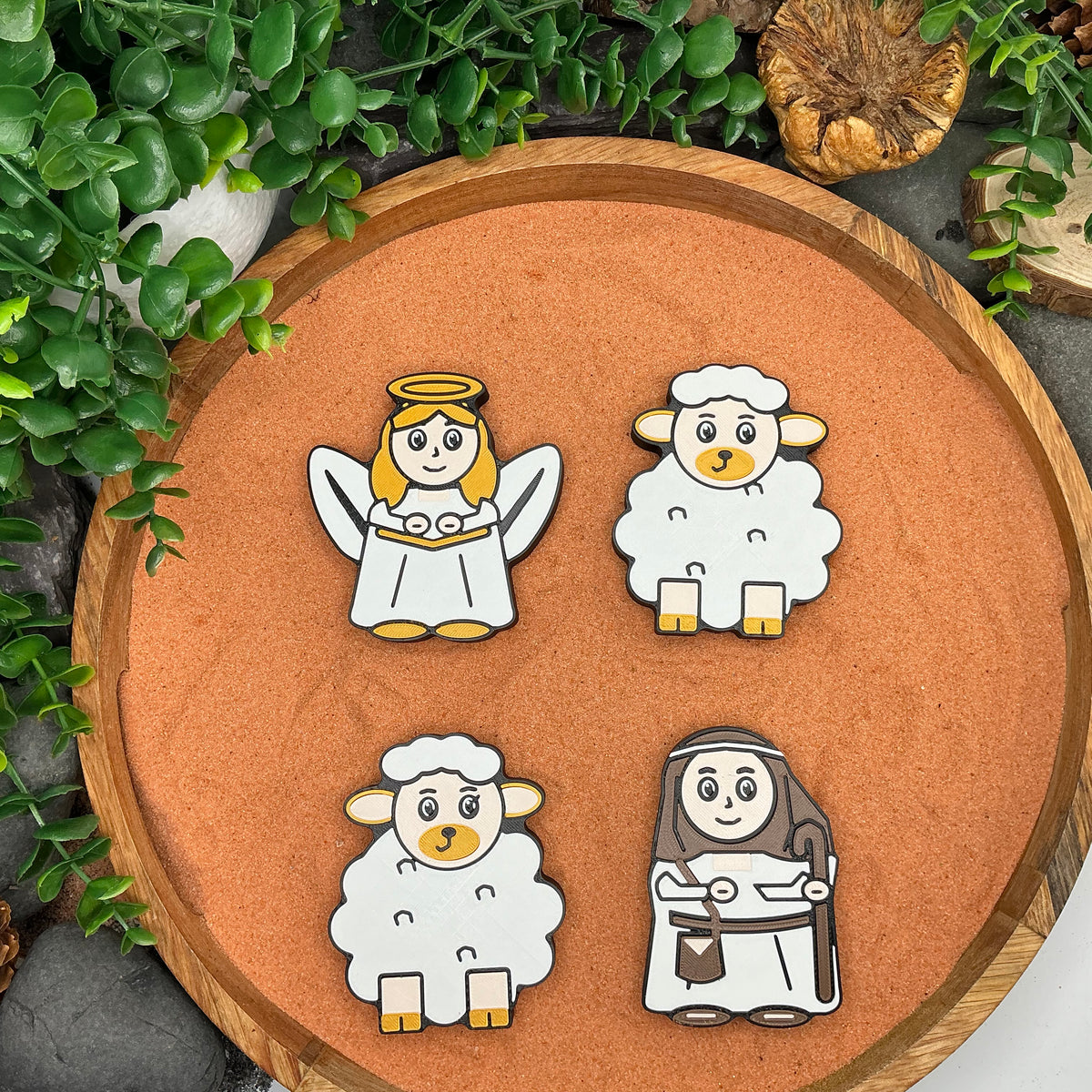 Nativity angel, shepherd with a crook and two sheep laid flat in a wooden tray