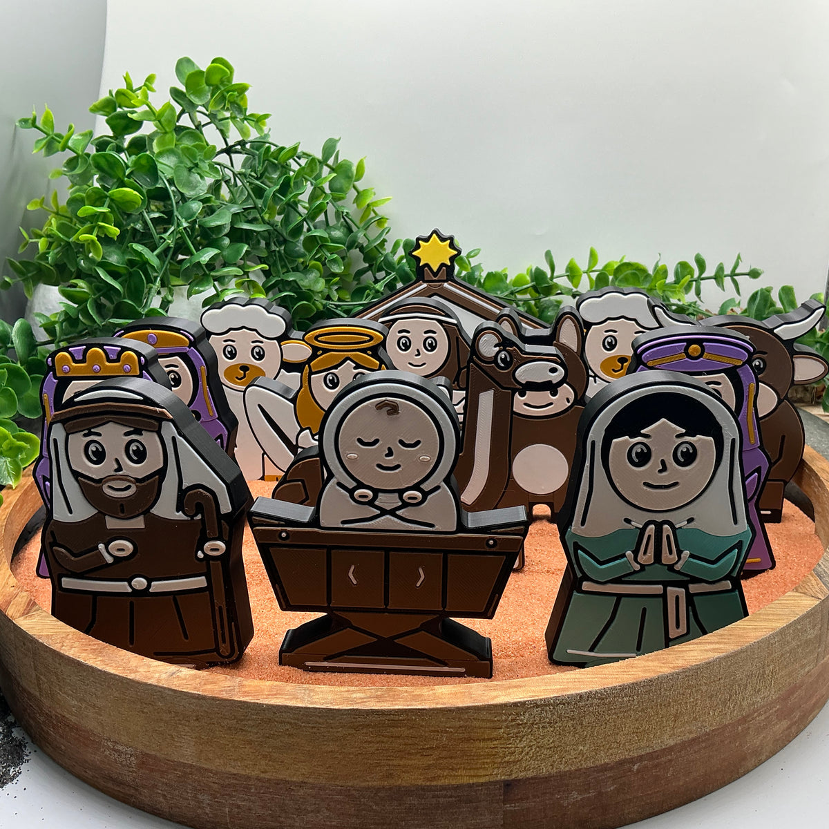 Nativity characters and animals standing together in a wooden tray, with Mary, Joseph and baby Jesus at the front