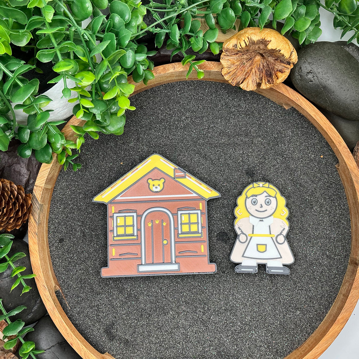 Large Goldilocks character beside the yellow-roofed Three Bears cottage, viewed from above