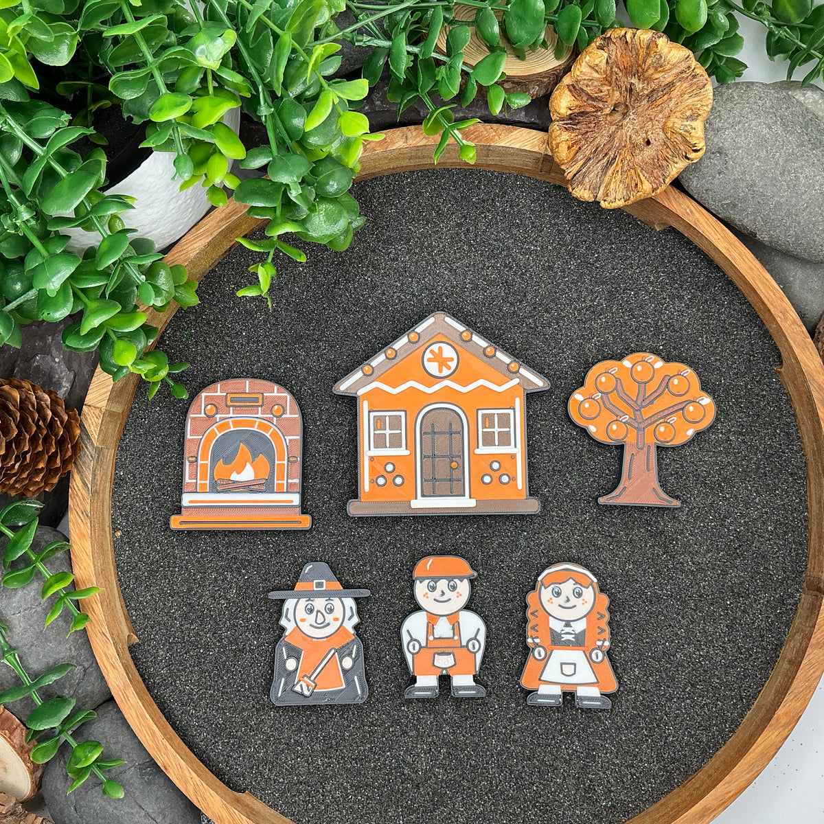 Small Hansel and Gretel six-piece story set laid flat in a wooden sand tray