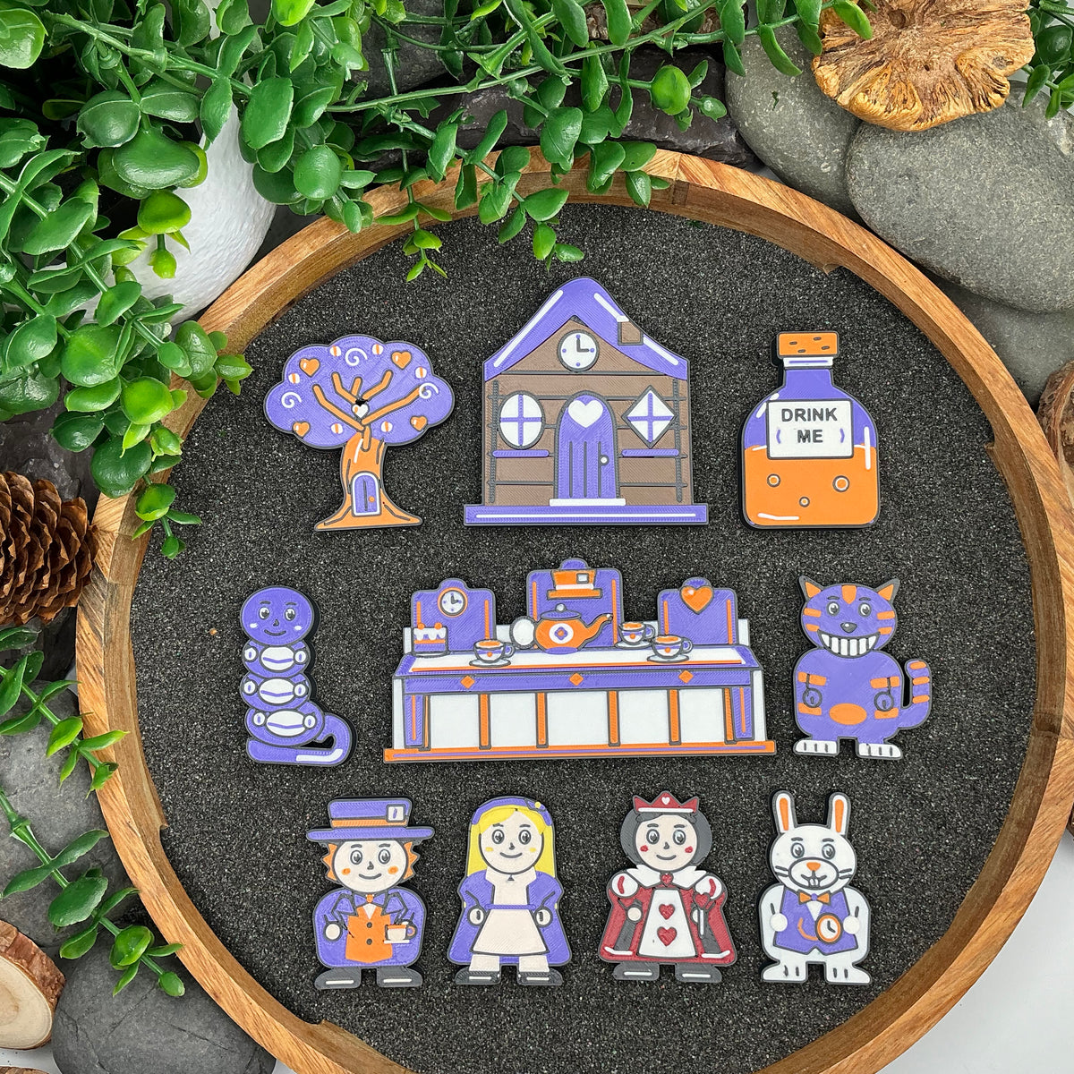 Small ten-piece Alice in Wonderland set laid flat, including blonde Alice, cottage and tea-party scene