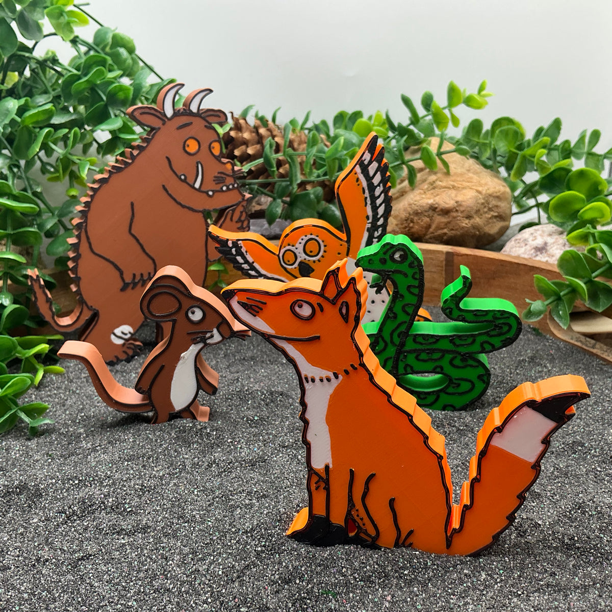 Woodland story characters grouped together in sand