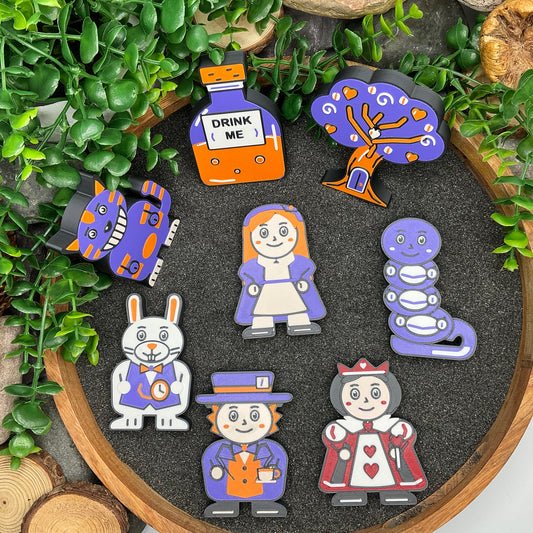 Alice in Wonderland 8 piece story set laid flat in a wooden tray with dark sand