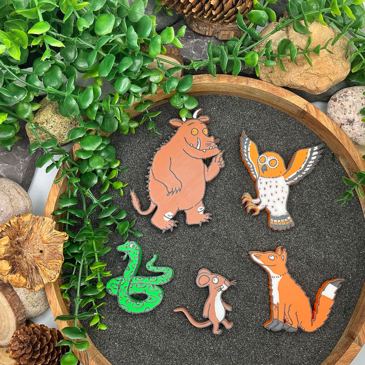 Five woodland story character figures laid out on a sand tray