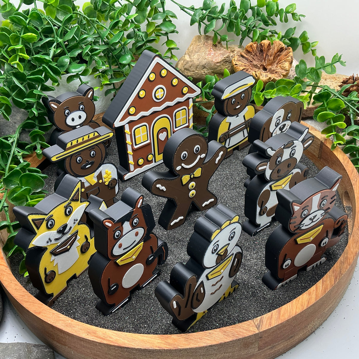 Gingerbread Man story figures arranged in rows in a wooden sand tray, side view