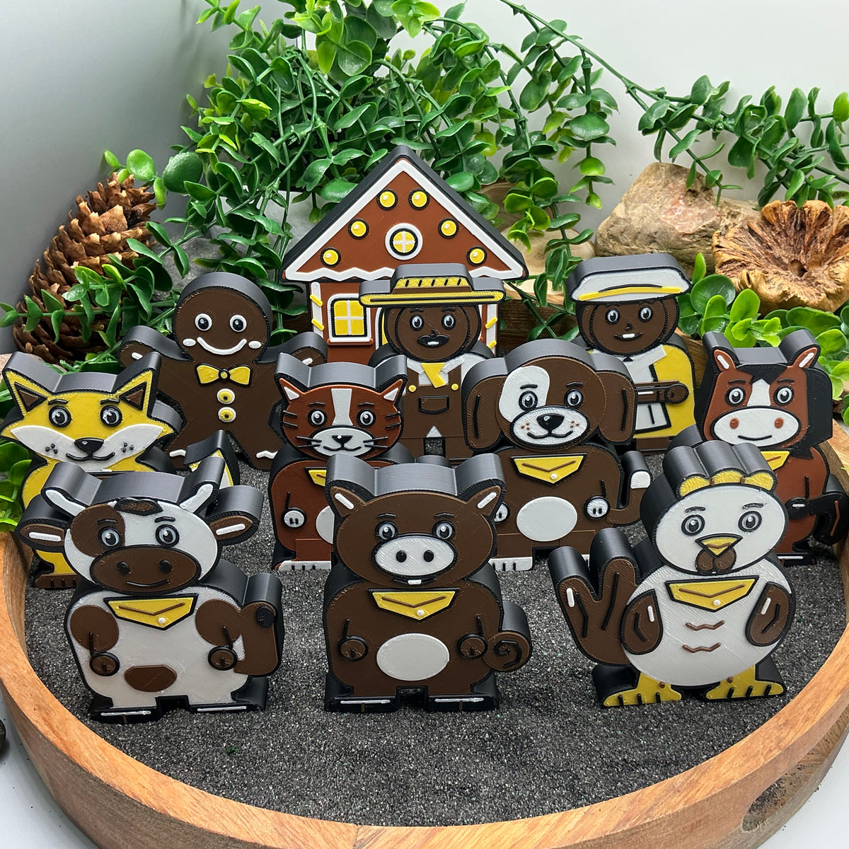 Gingerbread Man story characters, gingerbread house and seven animals standing in a sand tray