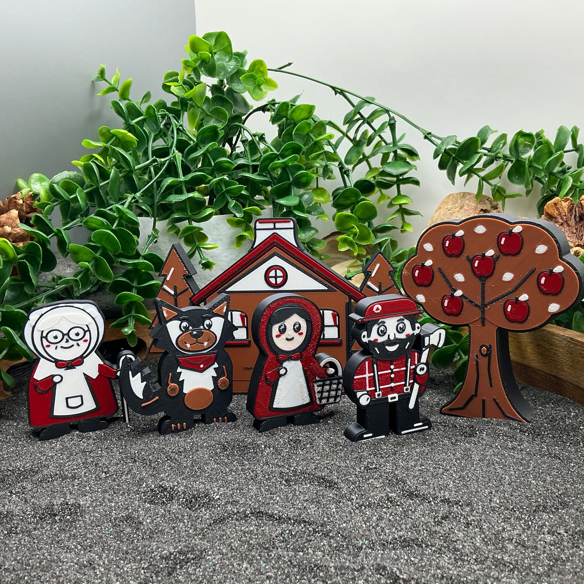 Little Red Riding Hood characters lined up with the cottage and apple tree