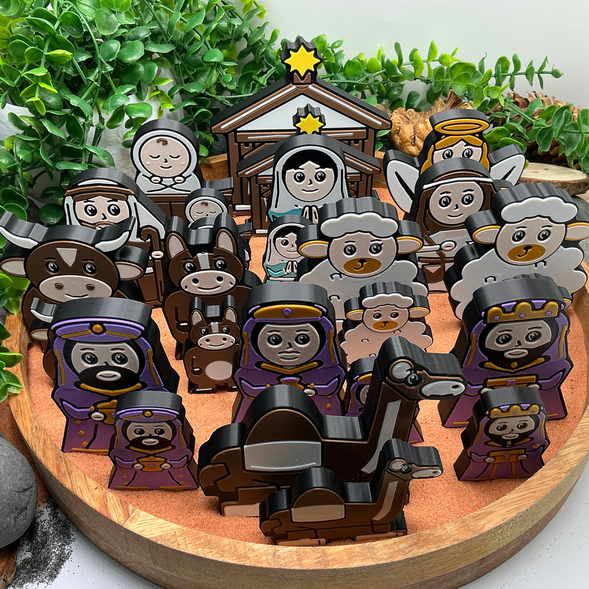 Large and Small Nativity sets standing together in a wooden tray, including figures, animals and two stables