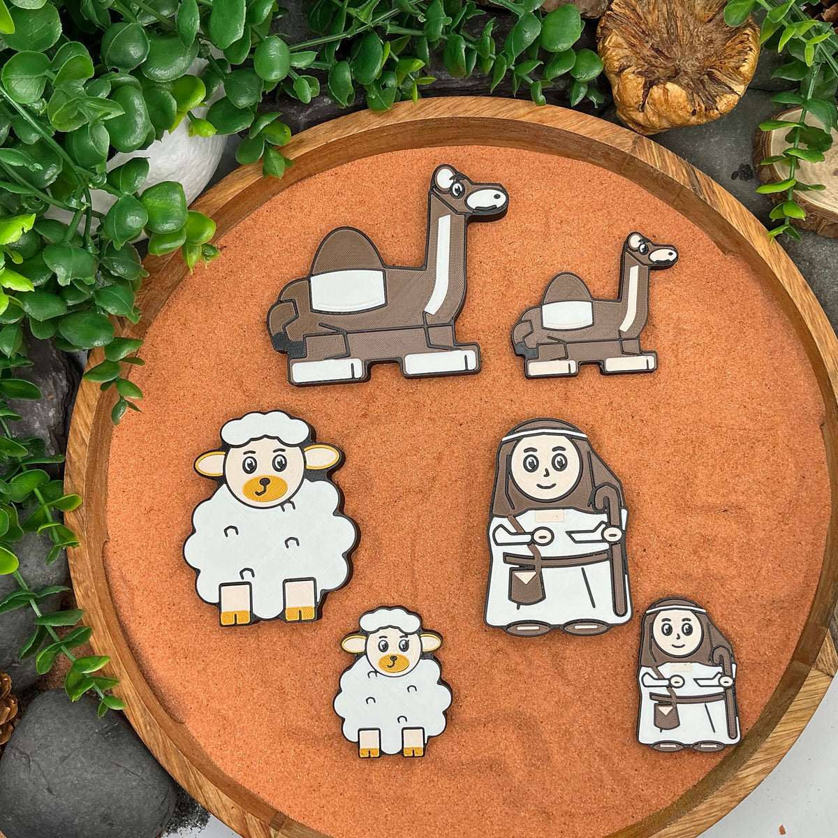 Large and Small camel, sheep and shepherd figures laid flat in a wooden tray