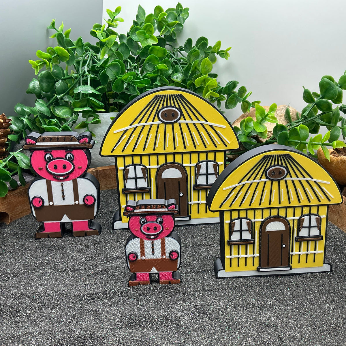 Large and Small pig figures beside yellow straw houses in two sizes