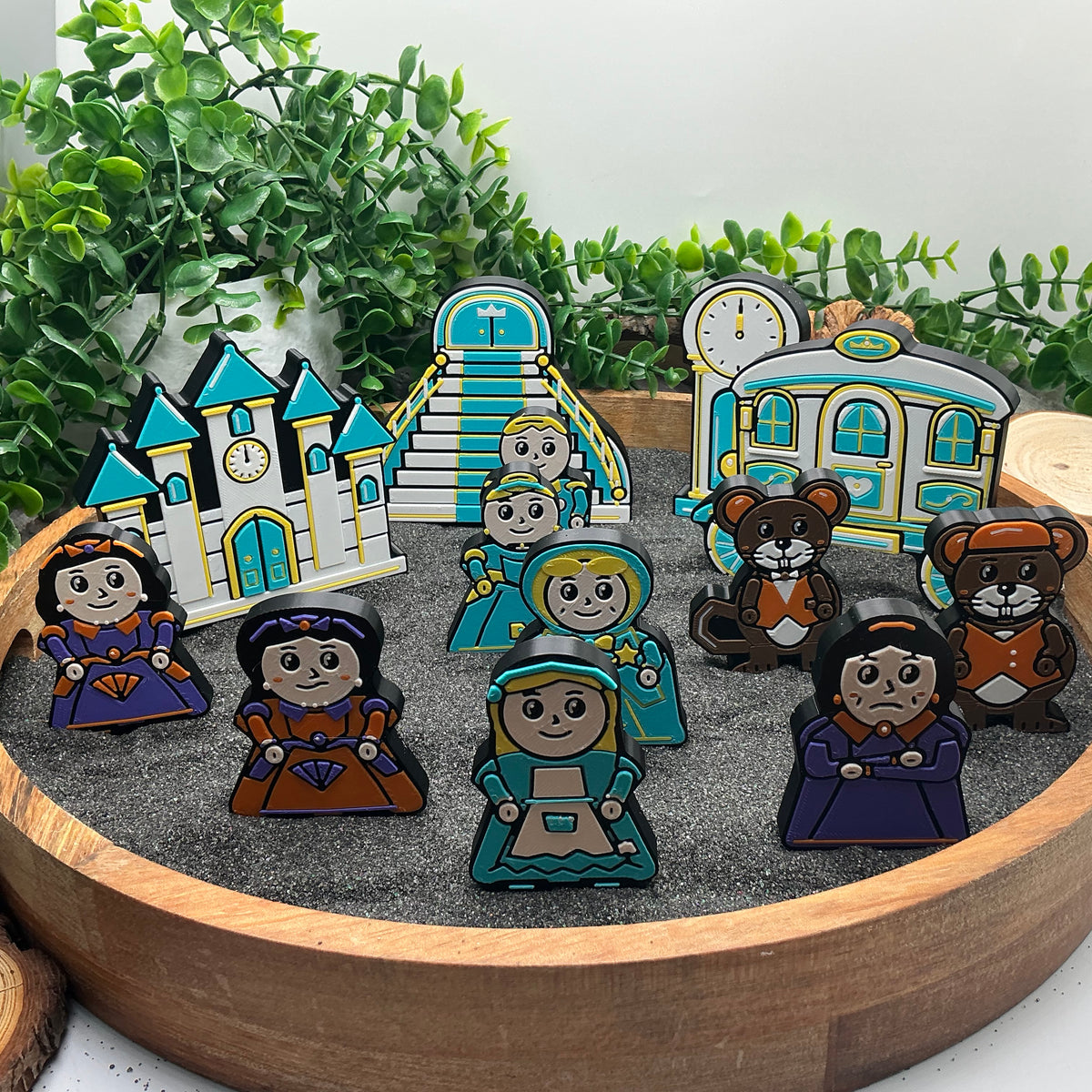Small Cinderella story characters and mice standing with the castle, staircase, clock and carriage in a wooden tray