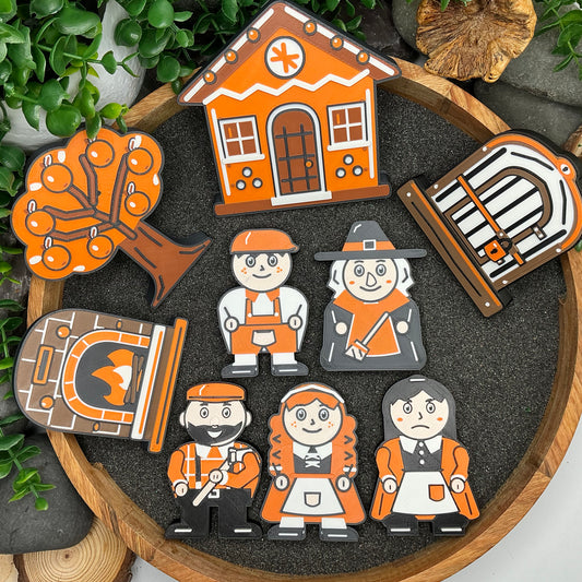 Large nine-piece Hansel and Gretel set laid flat in a round tray, with five characters, cottage, oven, cage and orange tree