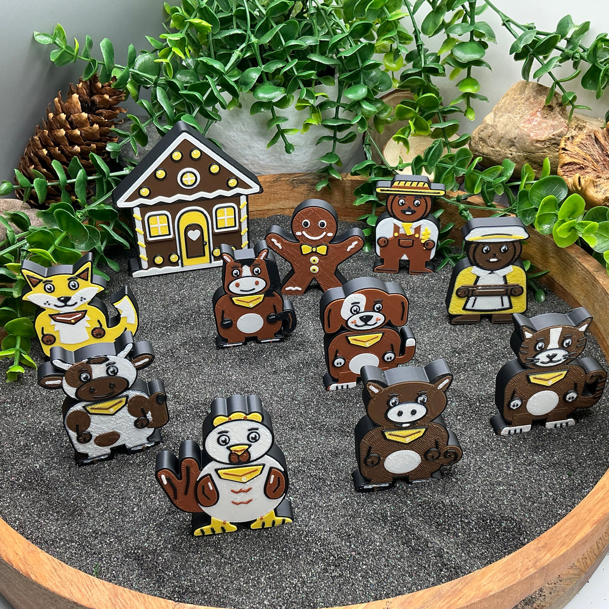 Small Gingerbread Man characters and seven animals standing around the gingerbread house
