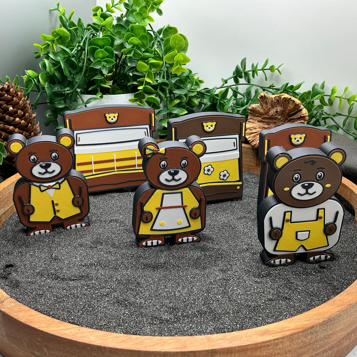 Daddy Bear, Mummy Bear and Baby Bear standing in front of their three bed pieces