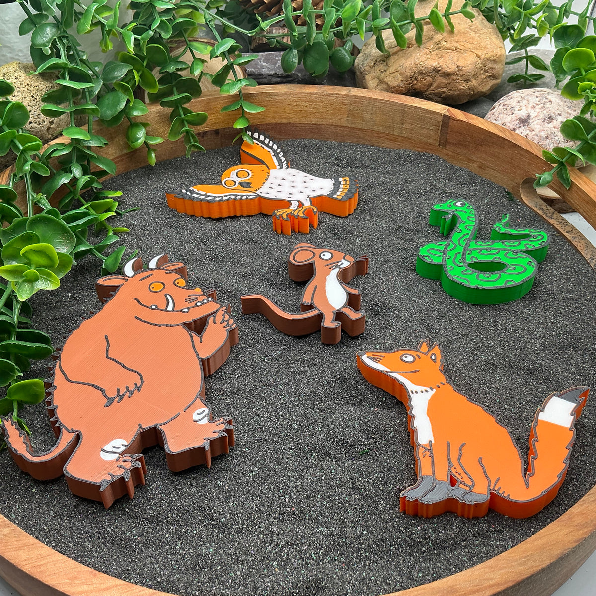 Five woodland story figures laid in a sand tray