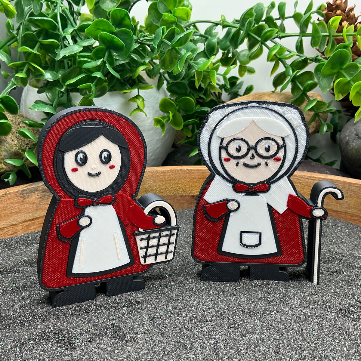 Close-up of Little Red Riding Hood with her basket and Grandma with her walking stick