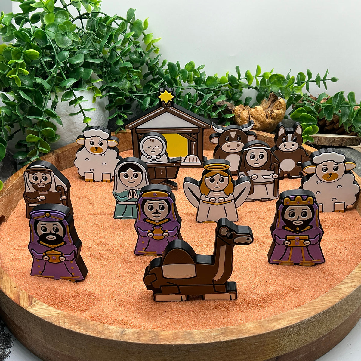 Nativity story characters standing with the stable, camel, donkey, ox and sheep in a wooden tray