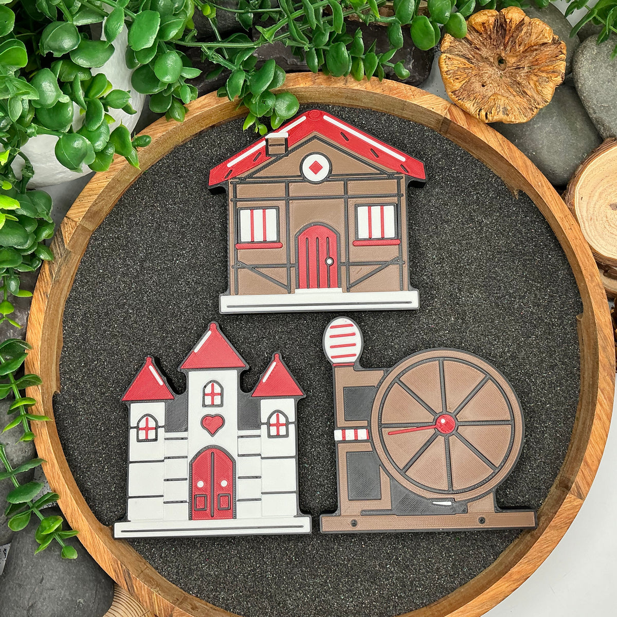 Three Snow White scenery pieces laid flat: dwarfs cottage, castle and spinning wheel