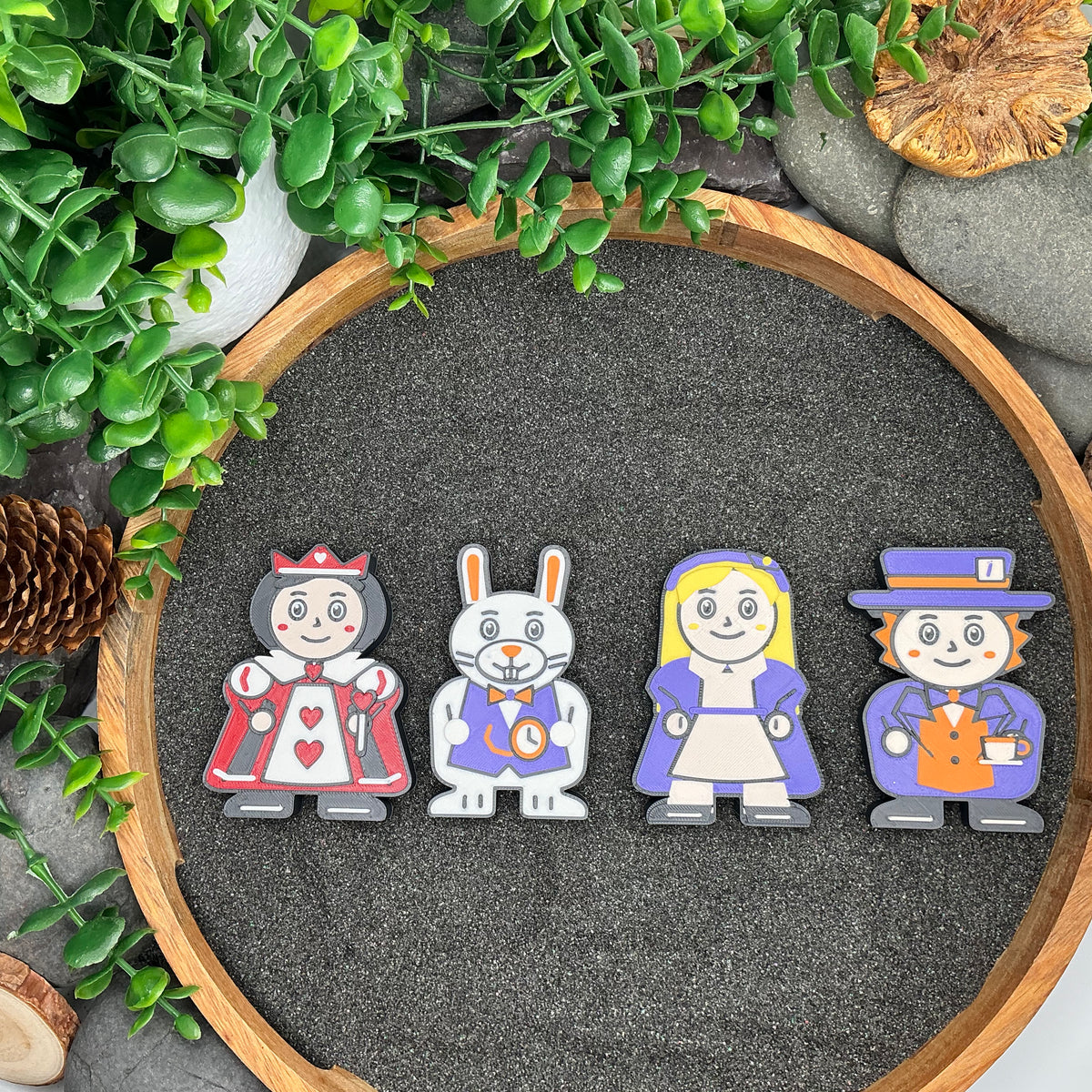 Large Queen of Hearts, White Rabbit, blonde-haired Alice and Mad Hatter figures laid flat
