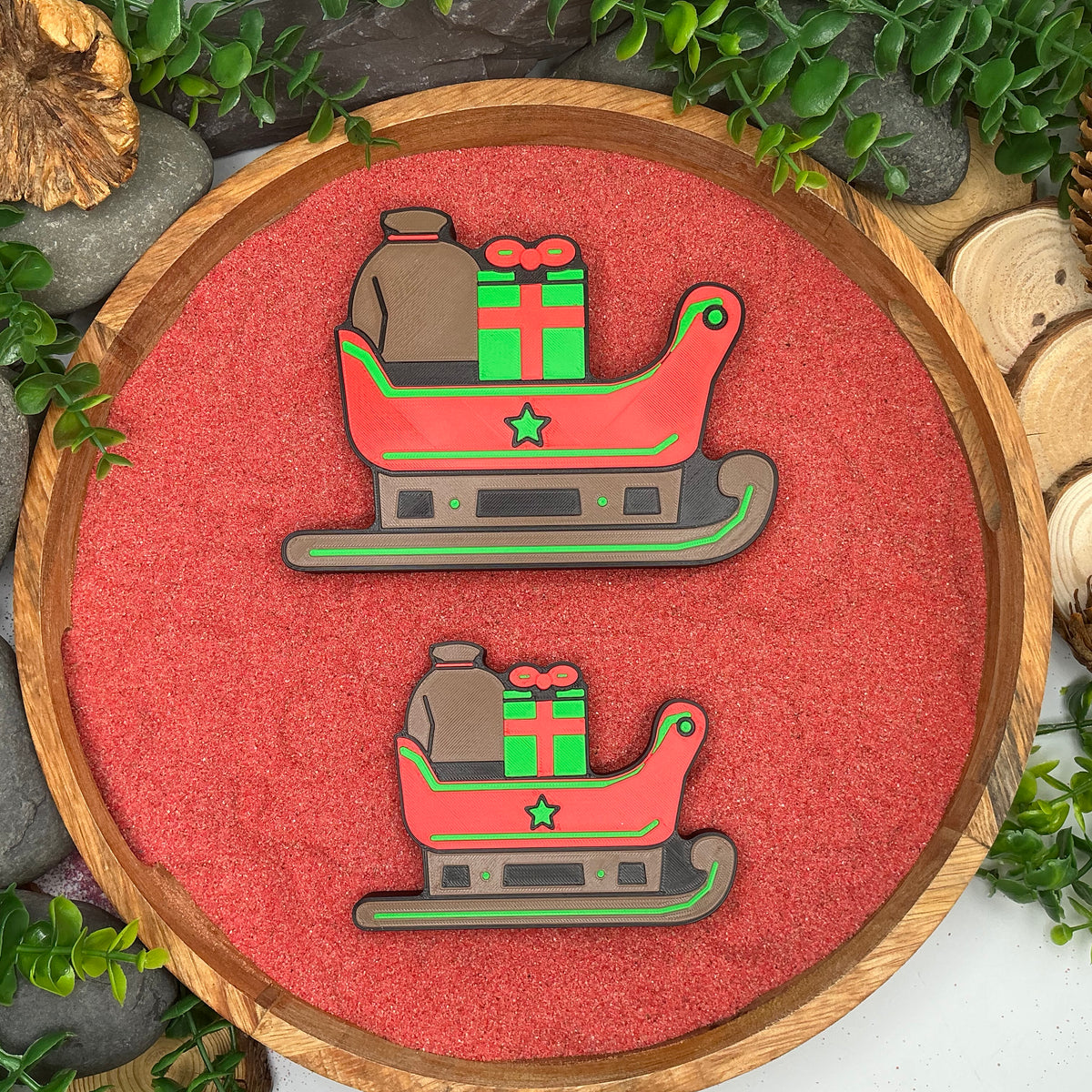 Large and Small Christmas sleighs with attached gifts laid flat side by side