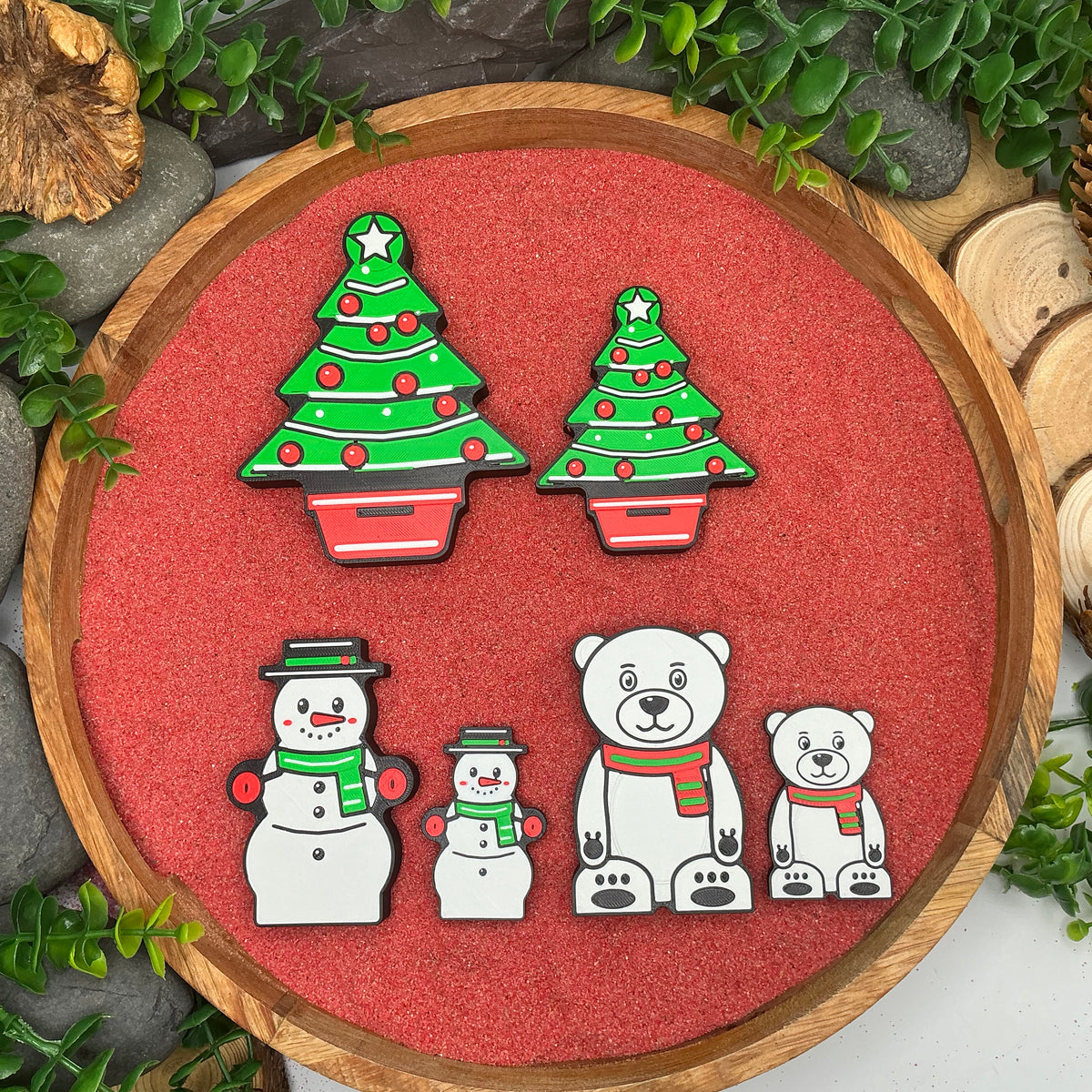 Large and Small Christmas trees, snowmen and polar bears compared in a wooden tray