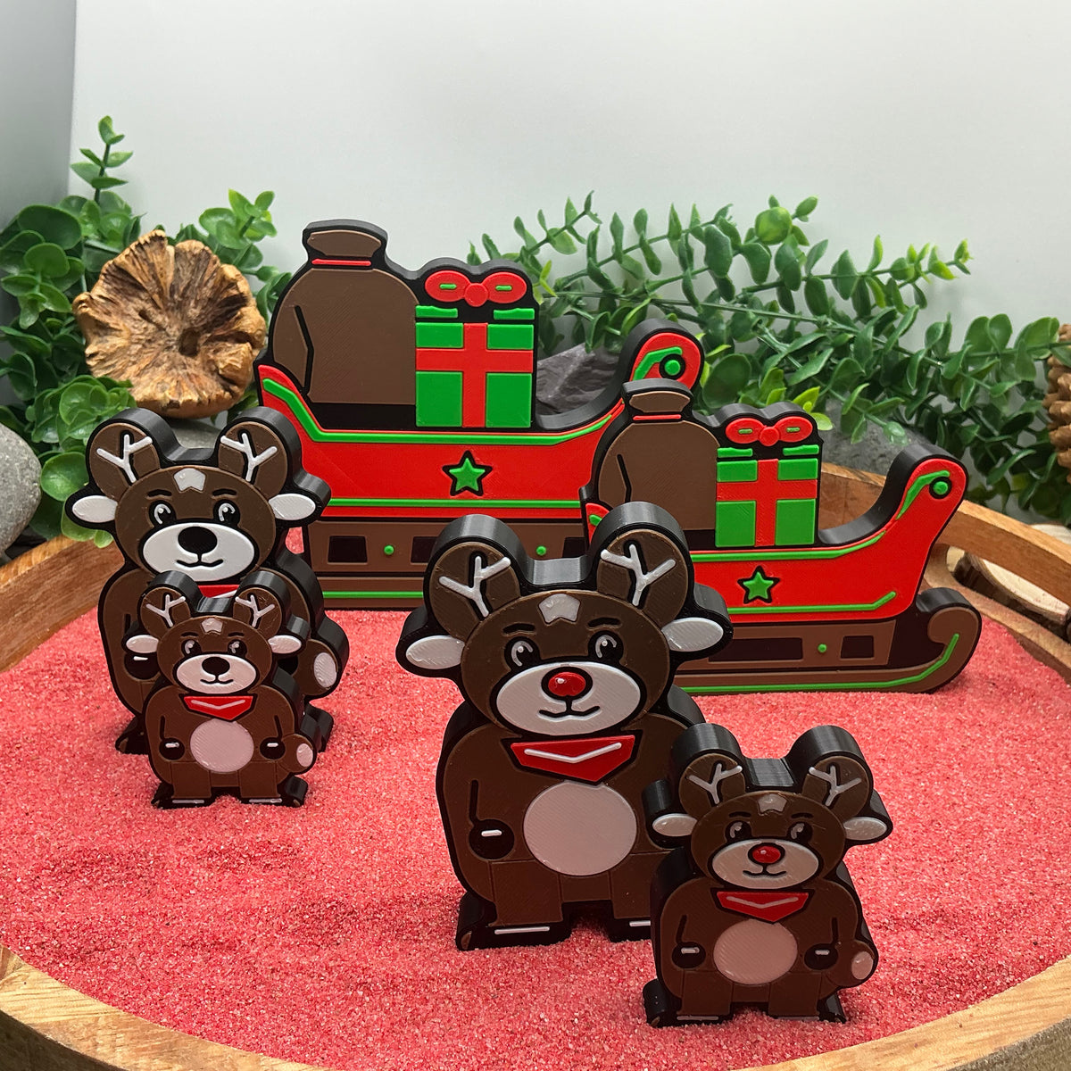 Large and Small Christmas sleighs and both reindeer standing together for size comparison