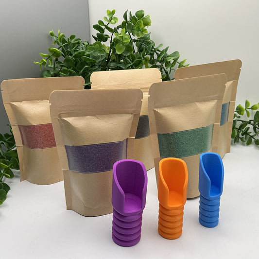 Five pouches of coloured play sand with purple, orange and blue pouring scoops